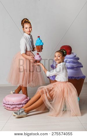 Beautiful Teenage Girls In Pink Tutu Skirts With Lollipops And Macaroons And Fansy Cakes In Studio O