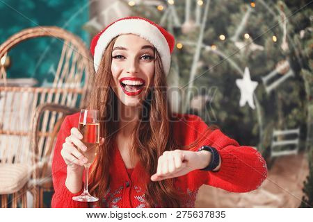 Attractive Christmas Woman Wearing Santa Hat And Red Sweater Sitting On The Floor Near The Cozy New 