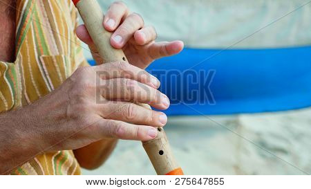 Close-up Hands Of Senior Man Playing Bamboo Flute
