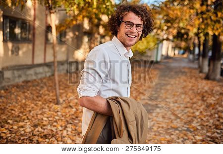 Horizontal Side View Potrait Of Young Businessman With Glasses Posing Outdoors. College Male Student