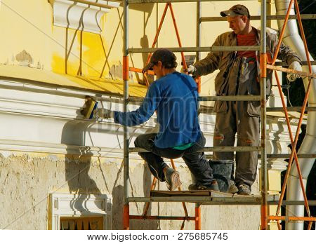 Moscow, Russia - 1 Oct 2016: Two Men Working While On The Scaffolding Redecorate The Facade Of An Ol
