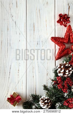 Spruce Branches, Cones And Red Berries On A White Wooden Background. Background For Christmas And Ne