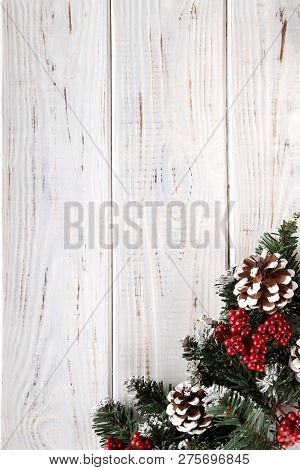 Spruce Branches, Cones And Red Berries On A White Wooden Background. Background For Christmas And Ne