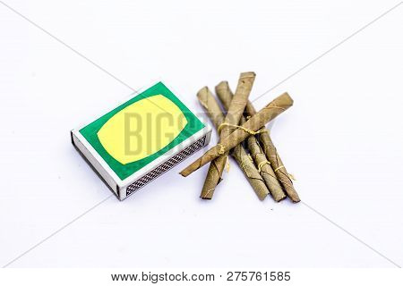 Close Up Of Mini Cigar Or Mini Cigarette Or Bidi Or Beedi Isolated On White With A Matchbox.