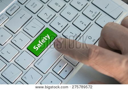 Closeup Picture Of Safety First Button Of A Modern Keyboard. A Male Finger Presses A Color Button On