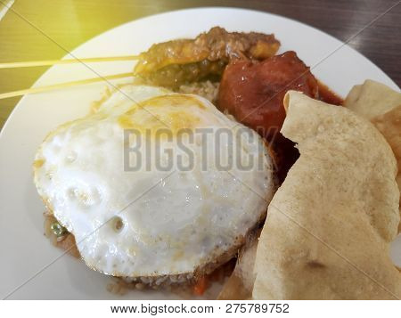 Selective Focus Of Fried Rice With Satay Egg And Papadum