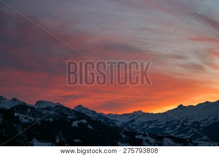 Shades Of Orange And Pink Clouds Explode Over The Snow-capped Alps In This Epic Mountain Sunset