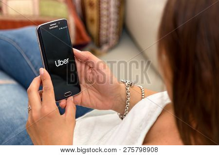 Rosario, Argentina - October 28, 2017: Young Woman Holding Cell Phone Showing  Uber App On Screen. U