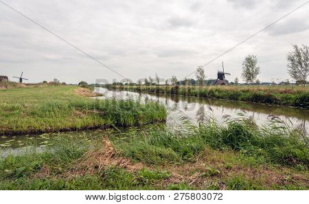 Typical Dutch Polder Landscape With Windmills. The Photo Was Taken Near The Village Sleeuwijk In Nor