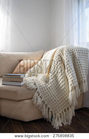 Stylish Brightly Interior Of Living Room. Inviting Comfortable Sofa With Handmade Woolen Blanket And