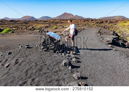A Tourist Guy Looking At Info Table Near Caldera De Los Cuervos, Timanfaya National Park, Lanzarote,