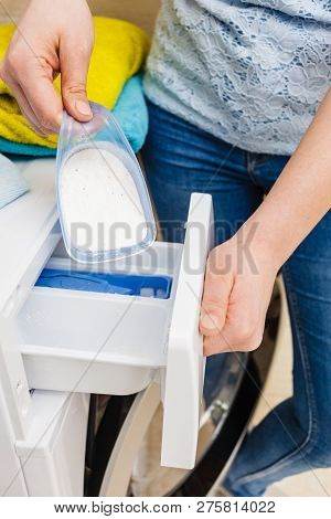 Washing Powder Detergent And Measuring Cup Pouring Into Machine. Household Duties, Clothes Laundry O