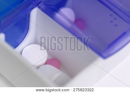 Medication Shown In A Daily Pill Box Dispenser  With Braille Markings, Copy Space At Base