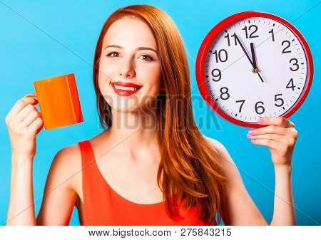 Redhead Girl With Tea Cup And Huge Clock On Blue Background.