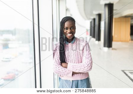 Attractive Young Businesswoman Staring Thoughtfully Through Office Windows At The City Skyline