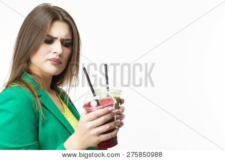 Healthy Food Eating. Choosy Thinking Woman With Both Green And Red Detox Vegetable Smoothie. Posing 