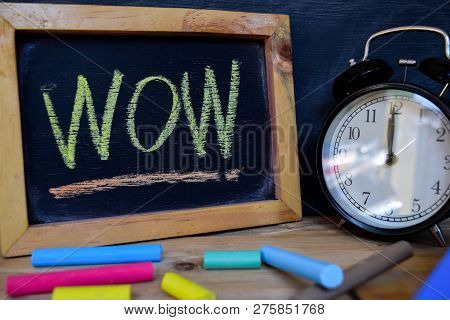 Wow. Back To School Concept. Alarm Clock On Wooden With Blackboard On Background