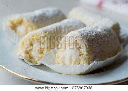 Mini Roll Cake With Vanilla Cream, Coconut And Powdered Sugar.