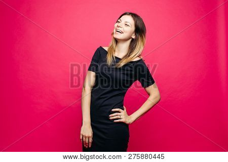Woman In Black Dress Lauthing Emotionaly Posing With Hands On Waist.