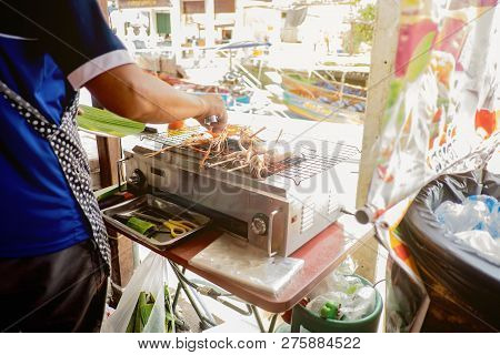 Unacquainted People Selling Grilled Sea Food Beside The River In Amphawa Floating Market In Holiday 