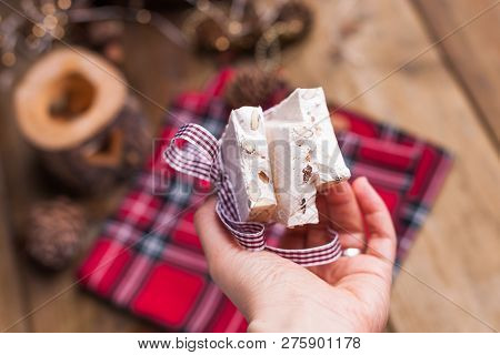 Traditional Italian Sweet From Nougat And Almond For Christmas. Candy In A Female Hand. Free Space F