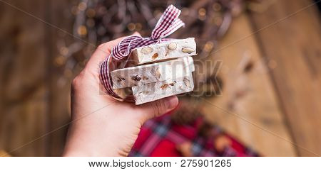 Traditional Italian Sweet From Nougat And Almond For Christmas. Candy In A Female Hand. Free Space F