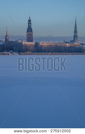 Riga View In Winter; Riga, Capital City Of Latvia In Winter Time. View Of Church And Cathedral. View