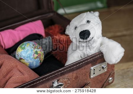Polar Bear Toy In Suitcase Of A Traveler, Also Small Globe Among The Clothes, Packed Into Open Vinta
