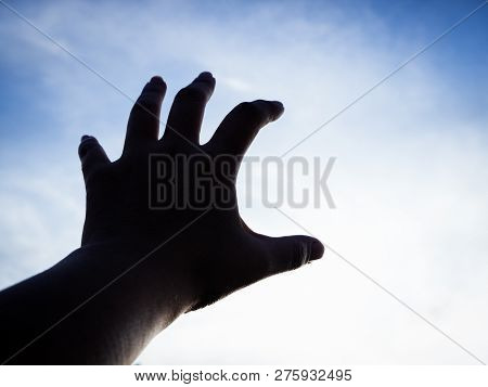 The Silhouette Humand Hand Reaching To The Sky