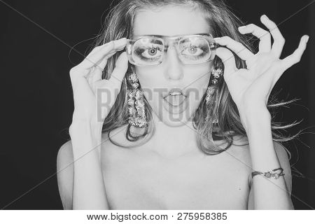 Optics Store Concept. Beauty Girl With Makeup And Big Earrings Jewelry, Dark Background. Woman With 