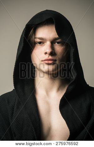 Young Pugilist In Black Hood Isolated On Gray Background. Handsome Fighter Before Going To Boxing Ri
