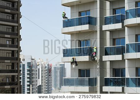 Three High-rise Workers Wash Windows Of A High-rise Building In Dubai