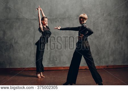 Young Couple In Black Dancing Ballroom Dance Paso Doble.