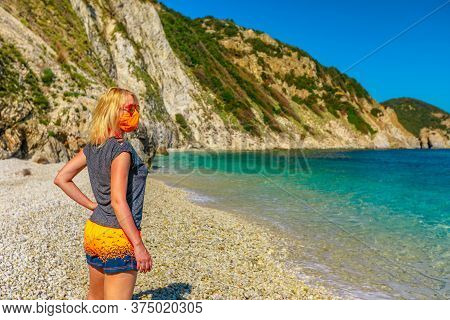 Lifestyle Woman With Orange Surgical Mask On Sansone Beach During Covid-19 Looking The Cliffs And Tu