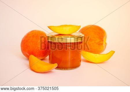 Fruit Jam. A Closed Glass Jar Of Jam, Sliced Peaches And Whole Fruit Isolated On A White Background.