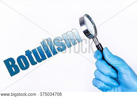 Botulism Text Written On The Background Of A Magnifying Glass In The Doctor Hand In A Medical Glove.