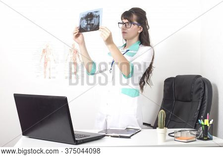 Dentist Doctor Watching X-ray Picture Orthopantomogram Of Jaw And Teeth. Dentures, Caries And Pulpit