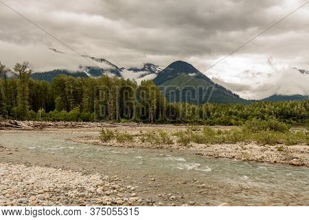 Braided Shames River As It Flows Into The Skeena River On An Overcast Day, With Woodland And Mountai
