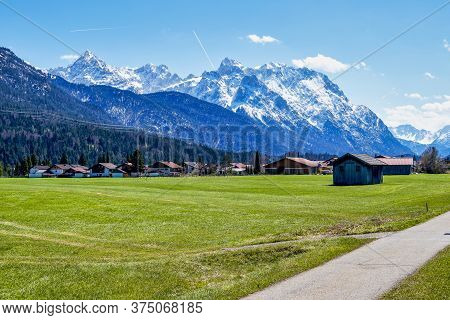 Wetterstein Mountains. View From Wallgau, Bavaria, Germany. Road Through The Ammergau Foothills With