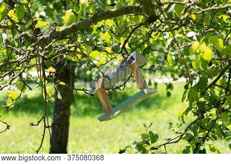 A Bird Feeder In A Tree Garden