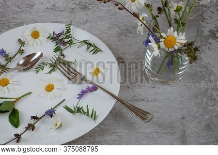 Flowers In White Plate With Fork And Spoon On Grey Textured Background, Vase With Wilf Flowers, Vege