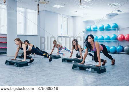 Young Fitness Women Using Step Platform At The Gym.  Training.
