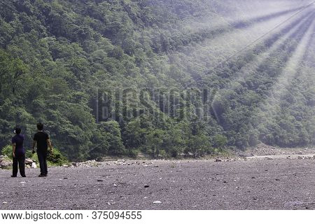 Rear View Of Two Men In Front Of Mountain In A Place Named Rishikesh In Indian Himalayas Terrain