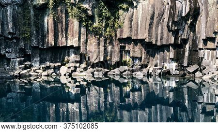 Rock Reflected In Water. Solidified Lava Near Water Of A Lake In Jeju Island. South Korea