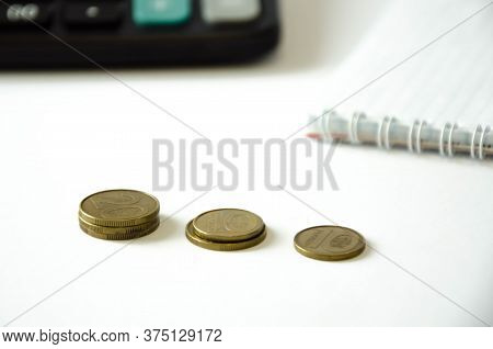 Calculator And Copecks Lie On A White Background Near The Diary