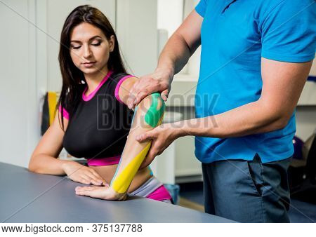 Kinesiotaping. Physical Therapist Applying Tape To Young Beautiful Womans Spine