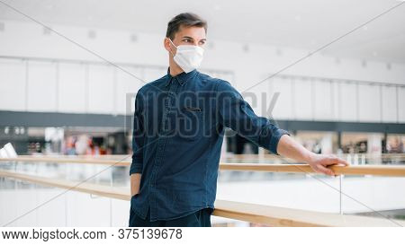 Serious Young Man In A Protective Mask Looking At The Deserted City.