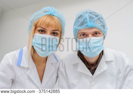 Two Doctors With Masck  In A Medical Office, Close View