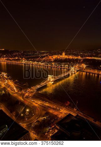 Aerial Drone Shot Of Chain Bridge Over Danube And National Gallery With Lights In Budapest Night