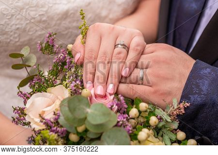 Close-up Of Two Wedding Rings On A Wedding Bouquet.
